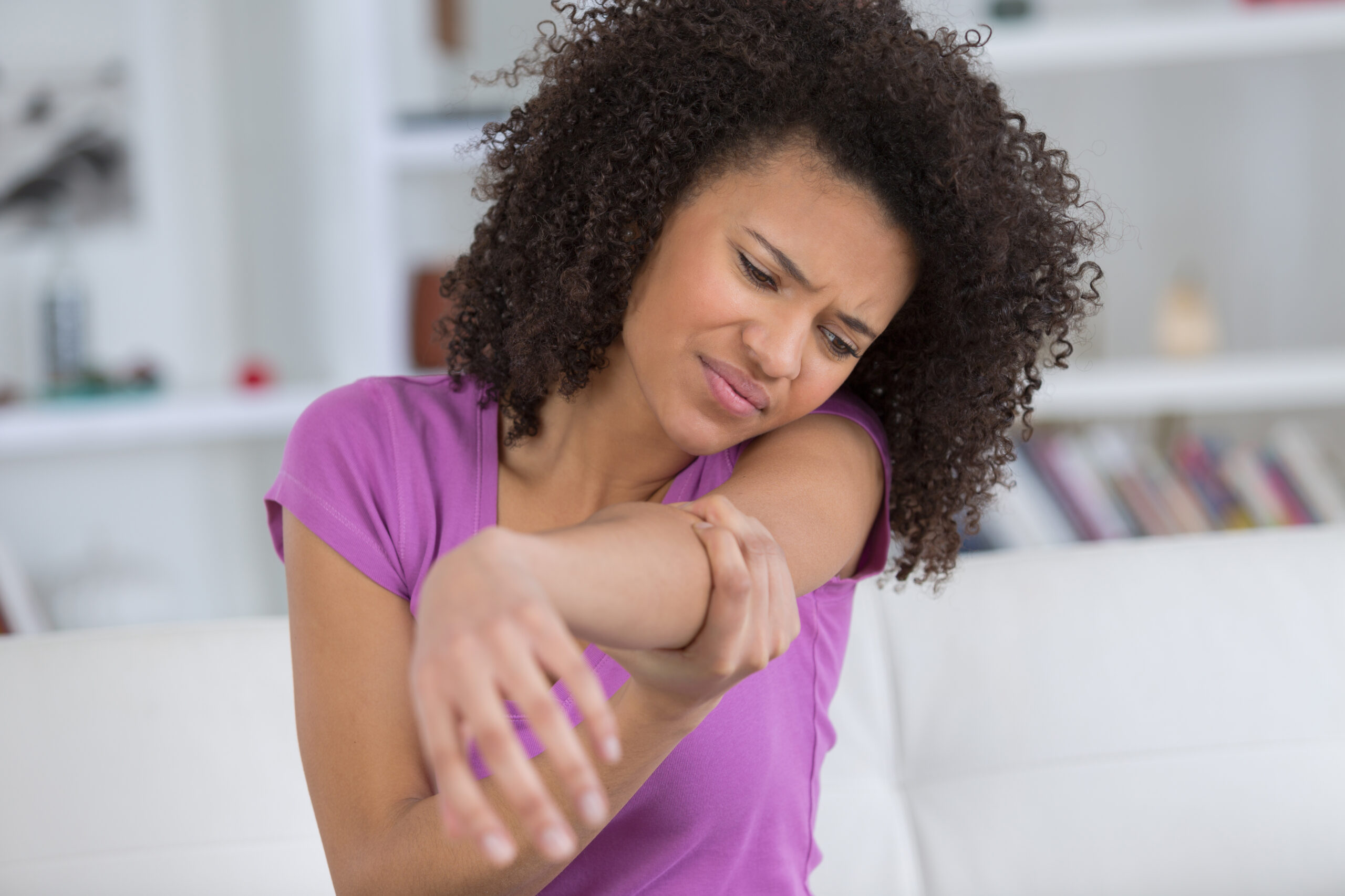 Person experiencing arm pain requiring chiropractic treatment in Salinas